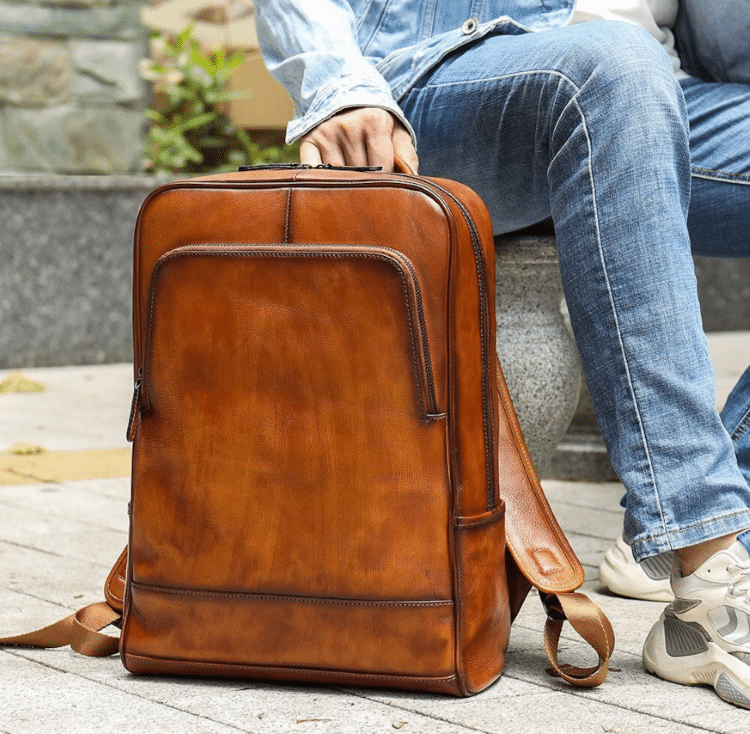 Photo Of Person In Jeans Sitting Next To Leather Backpack Laptop Holder