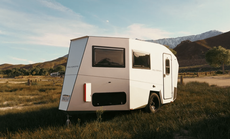 Camper Trailer Sitting In Grassy Field